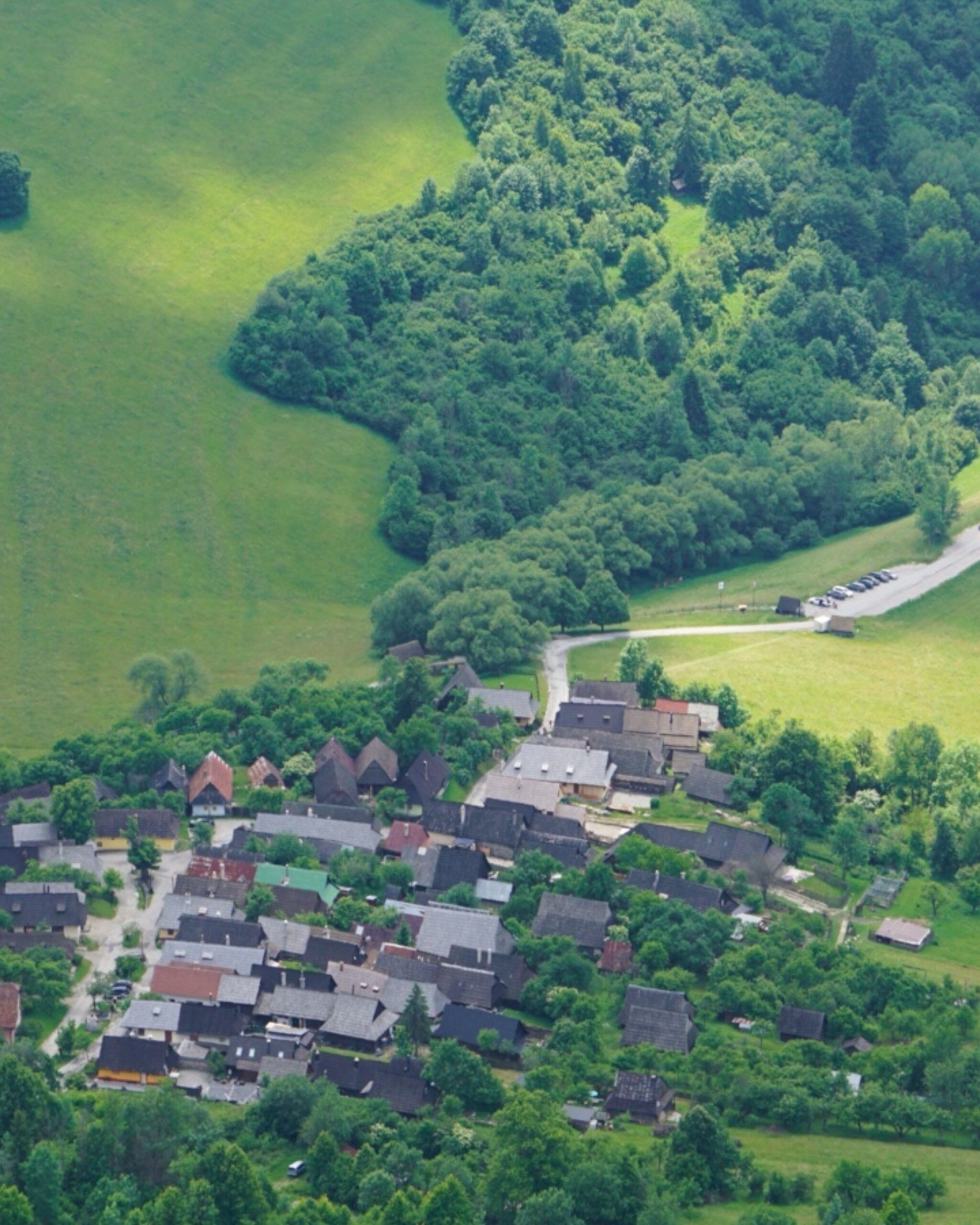 Widok na wioskę Vlkolínec UNESCO z góry,
Drewniane domy w dolinie pod lasem,
Panorama zielonej doliny z zabudową Vlkolínec.
